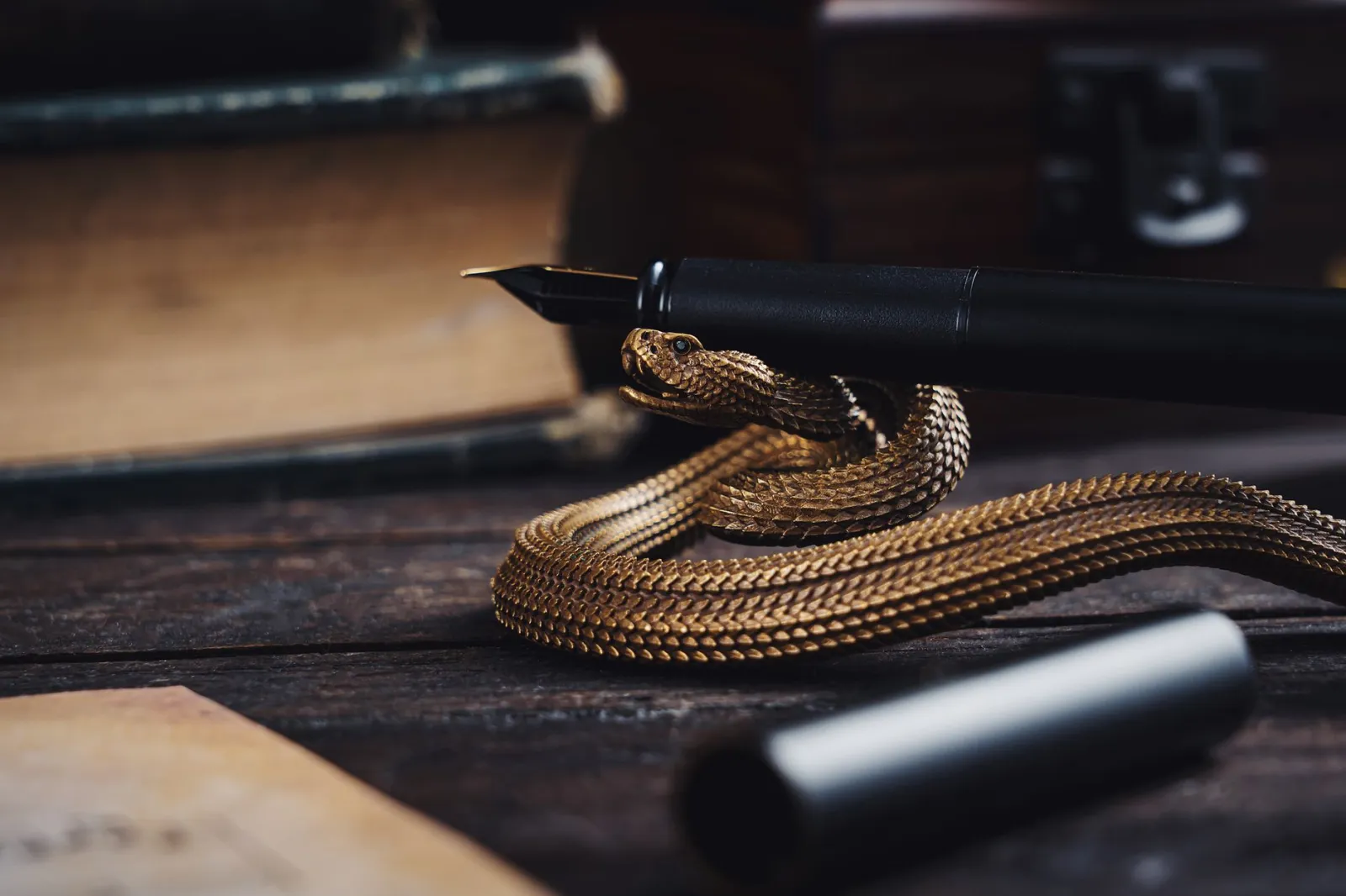Close-up of a fountain pen and snake on a vintage desk, creating an elegant and mysterious atmosphere.