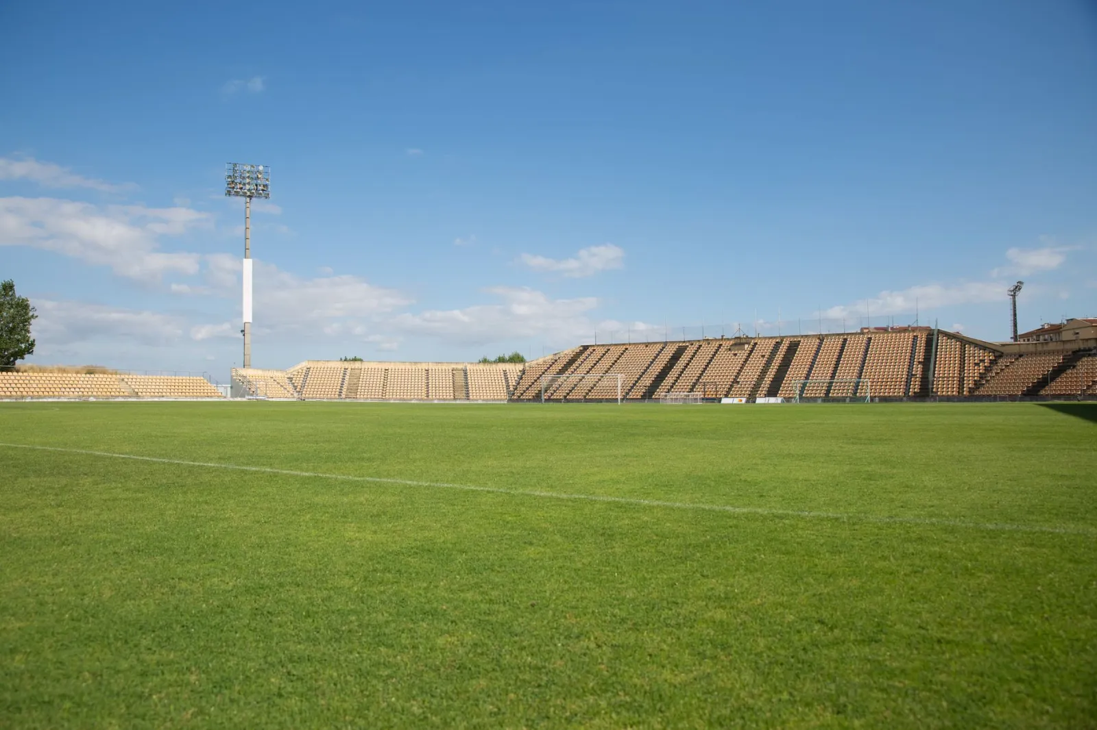 A bright, clear day at an empty football stadium in Portugal, perfect for sports events.