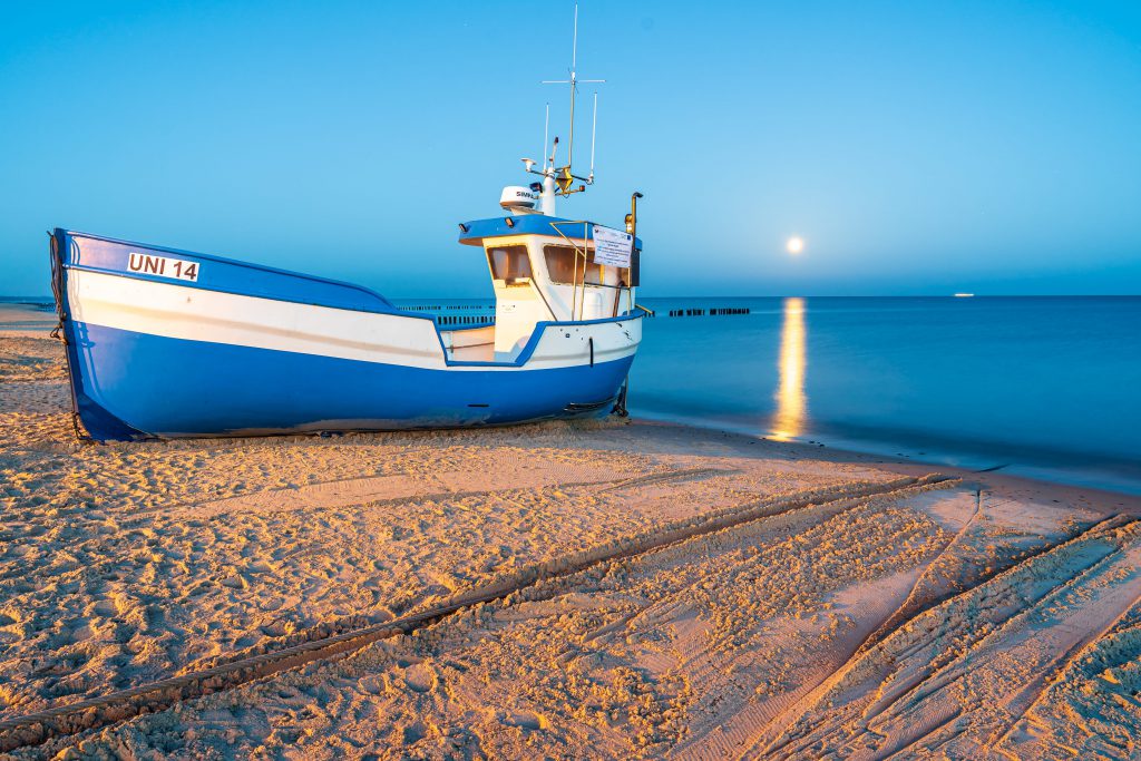 Mielno noclegi: łódka rybacka i widok na morze w tle
